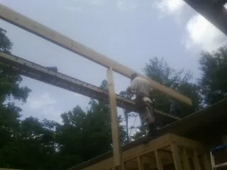 Carpenter setting a ridge beam over a new addition frame — Ice Dam Removal by Roofing Brothers in Lyon Station