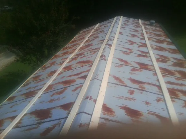 Rusted metal roof panels with new wood purlins before replacement — Storm Damage Roof Repair in Lyon Station by Roofing Brothers