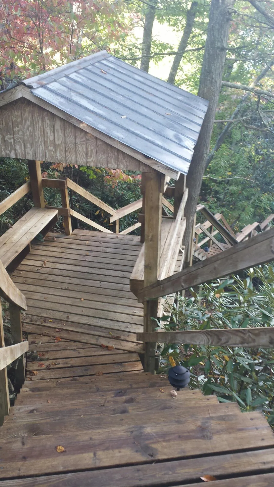 Metal roofed shelter over wooden steps on a wooded walkway — Skylight Repair & Installation work by our crew in Lyon Station