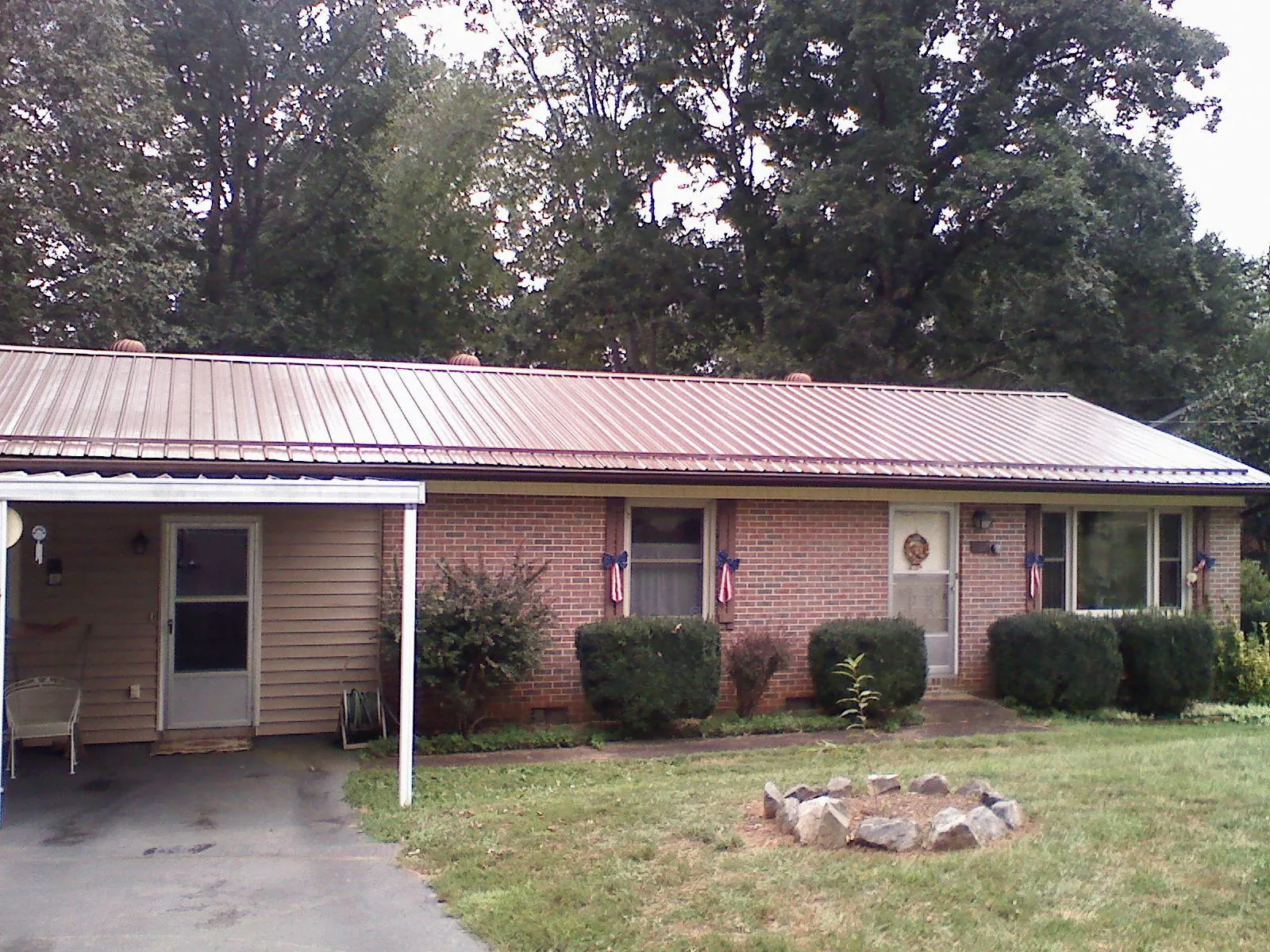 Bronze metal roof and carport on a brick ranch home — Roof Repair work by our crew in Lyon Station